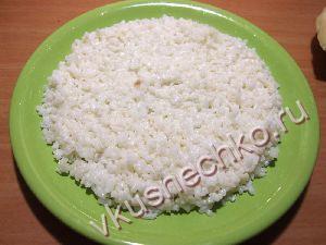Половину риса выложить на дно тарелки ровным слоем.